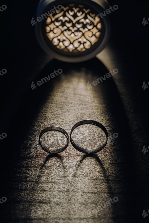 Preview: Close-up of two gold wedding rings on a black background