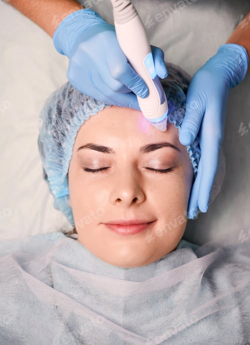 Preview: Charming young woman having skincare procedure in beauty salon.