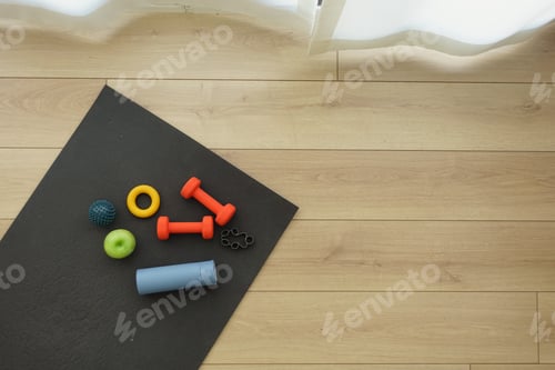 Preview: Exercise equipment arranged on a workout mat indoors