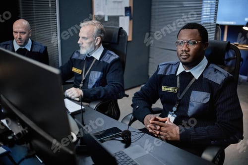 Preview: Middle Aged Multiethnic Security Officers Monitoring Surveillance Screens Indoors