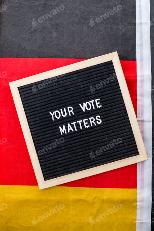 Preview: Letterboard sign with the words your vote matters with German flag on black background