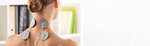 Preview: Back view of woman with electro stimulation electrodes on neck, panoramic shot