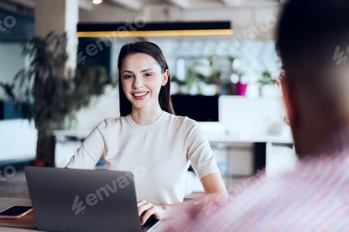 Preview: Male and female colleagues working at the table in office