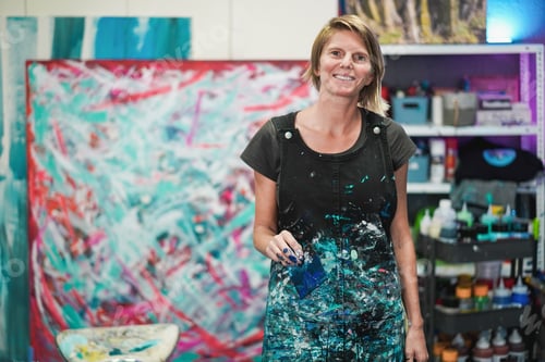 Preview: Portrait of senior artist painting inside her atelier studio at home - Focus on face
