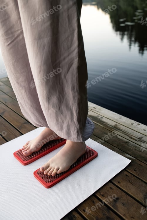 Preview: The woman's feet are on boards with nails. Yoga outdoors. Nail board. Nature.
