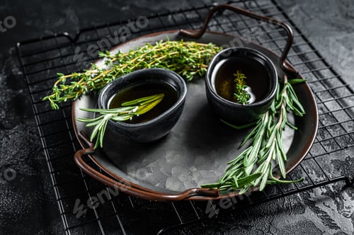 Preview: Assorted fresh herbs with olive oil. Top view. Dark background