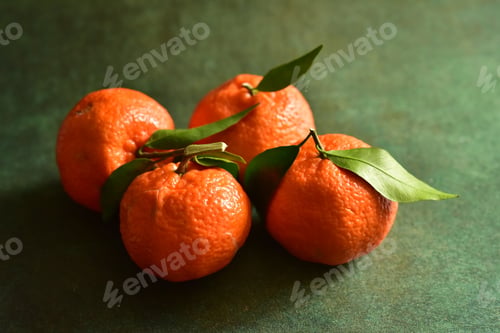 Preview: Fresh ripe tangerines with leaves on the table.