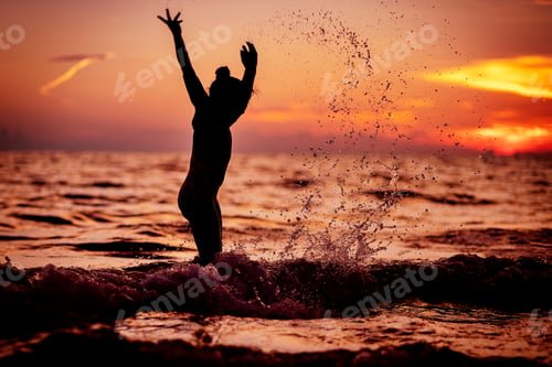 Preview: Young girl swimming in ocean during sunset.