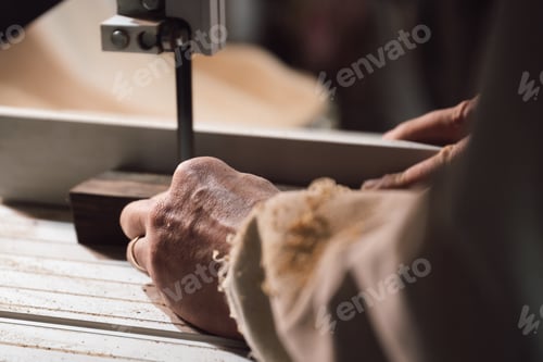 Preview: Closeup of a cabinetmaker cutting a piece of wood with an electric saw
