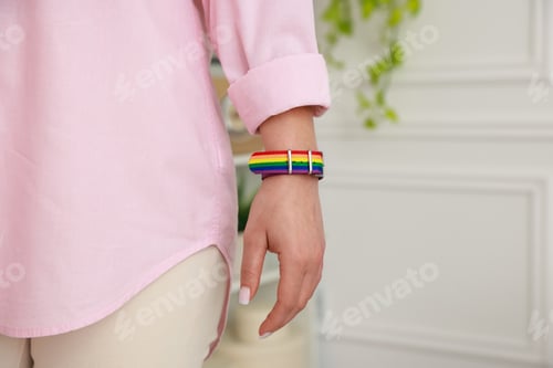 Visualização: Woman wearing wristband in LGBT colors indoors, closeup. Space for text
