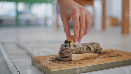 Preview: Hands holding aroma sticks indoors closeup. Woman using palo santo wood incense