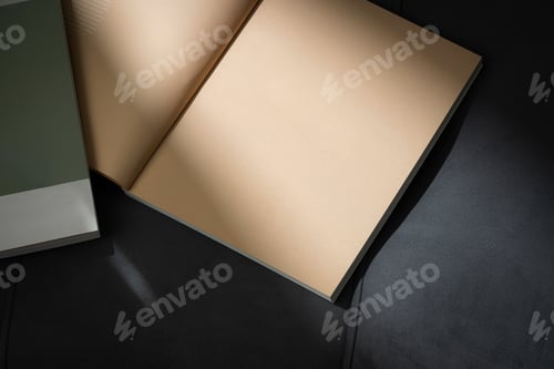 Preview: Stack of Magazines on a Black Leather Couch in Soft Light
