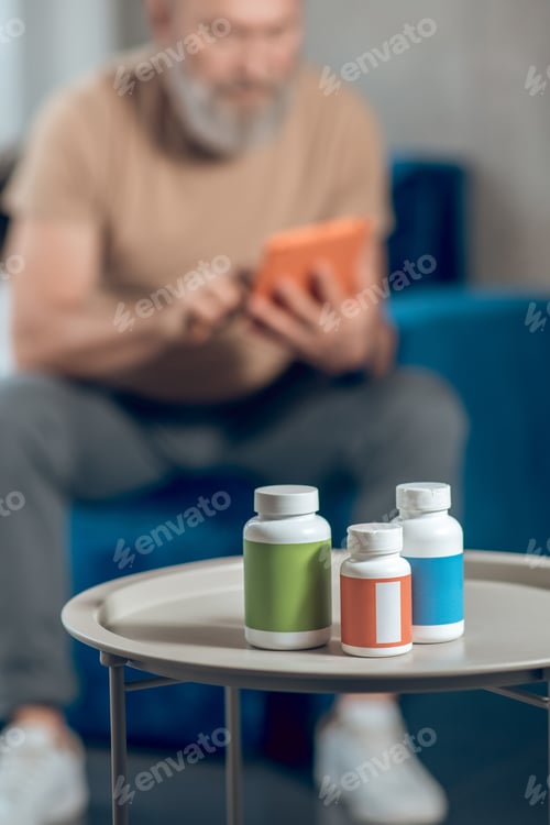 Preview: A mature man choosing vitamins and looking involved