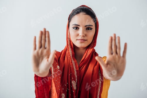 Preview: Selective focus of indian woman in sari showing refuse gesture isolated on grey