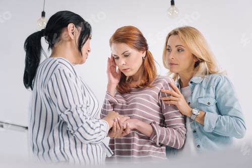 Preview: middle aged multiethnic women supporting upset female friend during group therapy