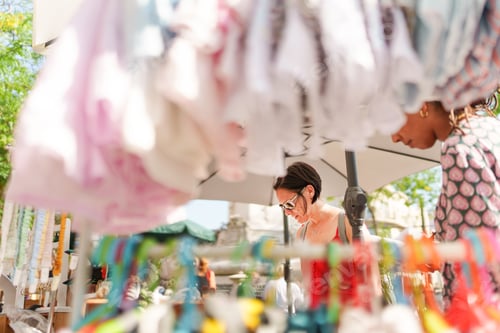 Preview: Women looking at clothes at a street market