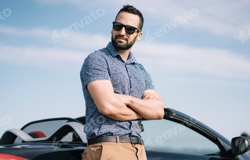 Preview: Attractive man posing in convertible car.