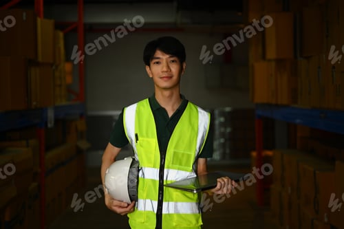 Preview: Portrait of male warehouse worker holding digital tablet standing in large retail warehouse