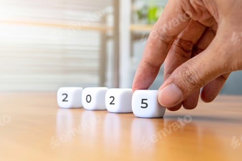 Preview: Closeup image of hand arrange a white cube with the number 2025.
