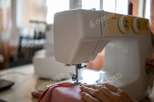 Preview: Detail. Sewing machine. . A young girl sews at home