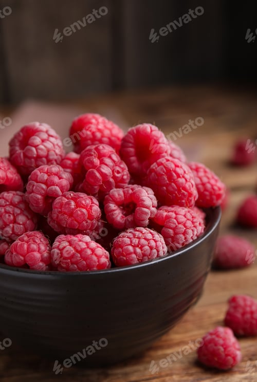 Preview: Bowl with fresh ripe raspberries on wooden table, closeup