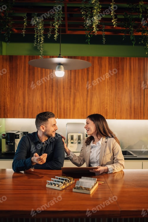 Preview: Smiling colleagues at eco friendly office working with solar panels.