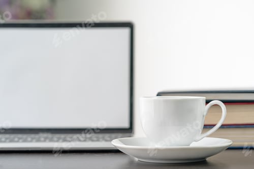Preview: Open Laptop, Books, and Tea Cup on Desk