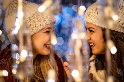 Preview: Happy women friends having fun, enjoying moments together in christmas decorated background