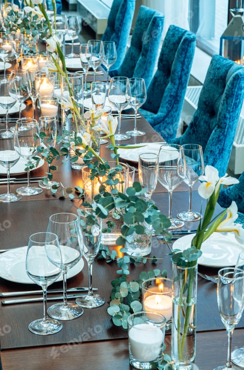 Preview: Table setting. On the banquet table there are plates with napkins and name cards, glasses and cutler