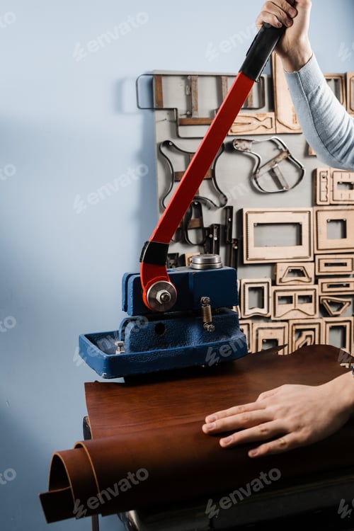 Preview: Artisan cutting leather shapes using professional press