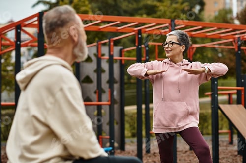 Preview: Mature couple enjoying a sunny day together in a city park while engaging in playful activities