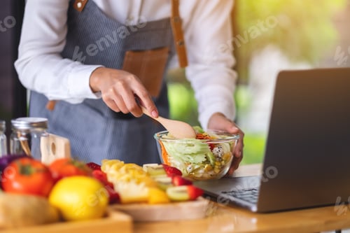 Preview: A woman videoblogger cooking in the kitchen and filming, online learning cooking class concept
