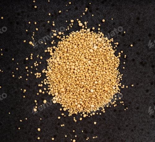Preview: pile of granulated dried yeast close up on black