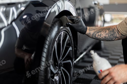 Preview: Professional man washing car and wheels in garage. Detailing. Tire care