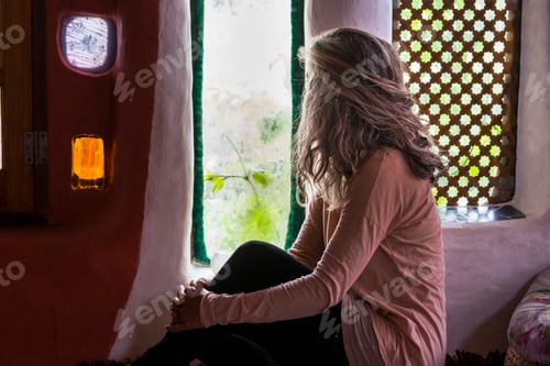Preview: Lonely caucasian woman at home look through the window