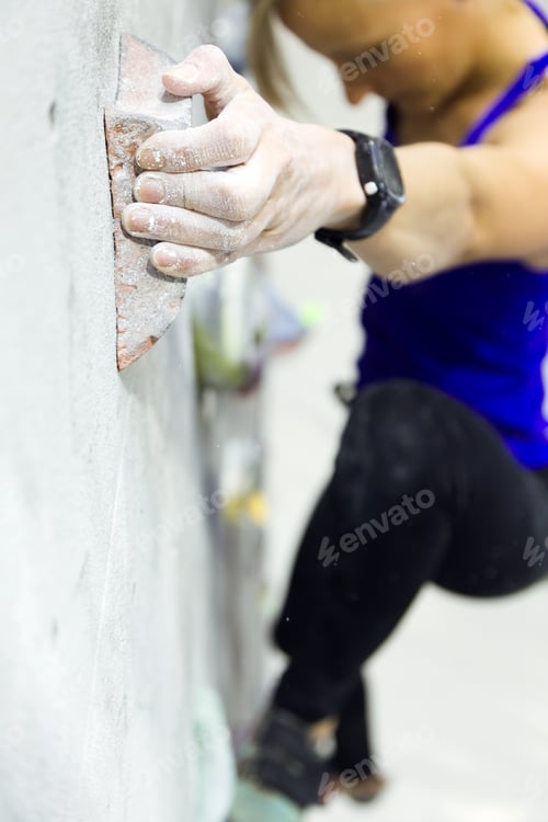 Preview: Fit woman rock climbing indoors at the gym.