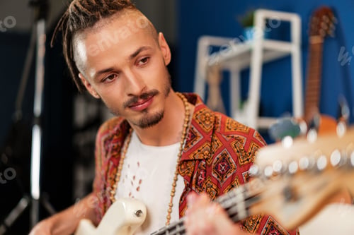 Preview: Young man guitar player sitting and performing on a couch