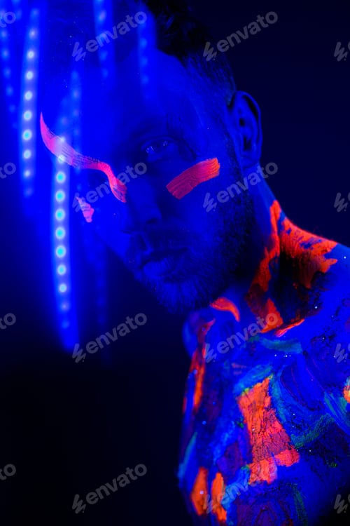 Preview: Portrait of a man with ultraviolet makeup and neon light in cyberpunk style.