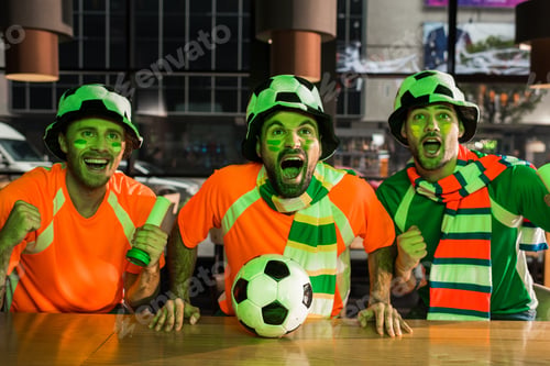 Preview: Football fans sitting at bar counter, screaming and watching game