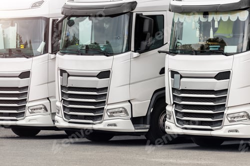 Preview: Fleet of new modern electric hybrid hydrogen or diesel white trucks parked in line row outdoors