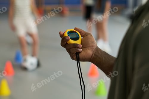 Preview: Coach Uses Stopwatch with Children Practicing Sports