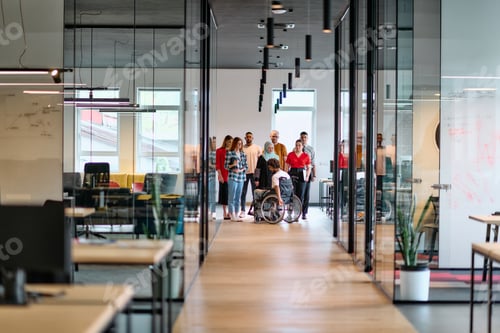 Preview: A diverse group of young business people walking a corridor in the glass-enclosed office of a modern