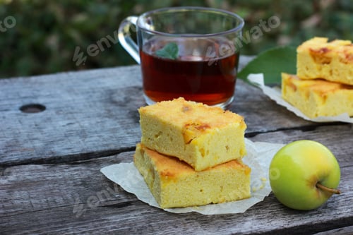 Preview: Autumn homemade charlotte fruit pie on a wooden ancient natural table with tea, teapot and mint