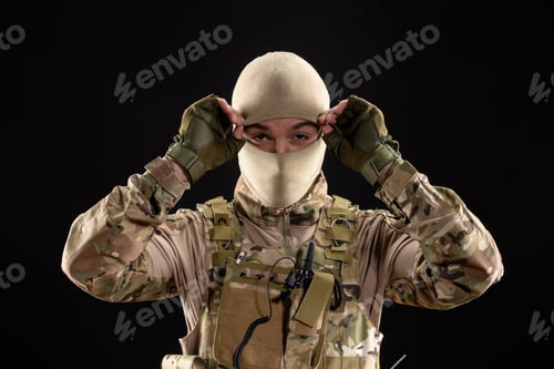 Preview: front view of young soldier in uniform on black background warrior tank