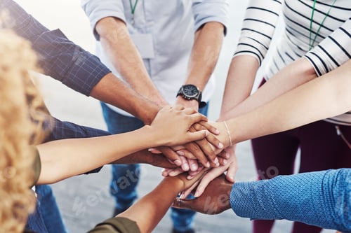 Preview: Closeup shot of a group of people joining their hands together in a huddle
