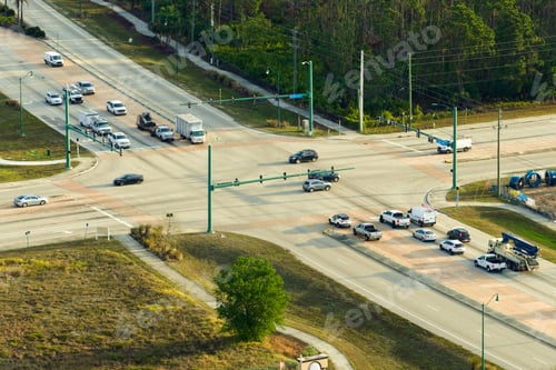 Preview: Top view of wide road with moving cars at intersection with traffic lights.