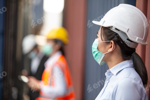 Preview: Asian woman worker wearing protective mask working at logistic warehouse