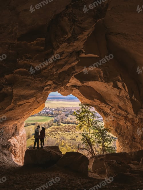 Preview: A romantic couple standing inside a cave with a beautiful view