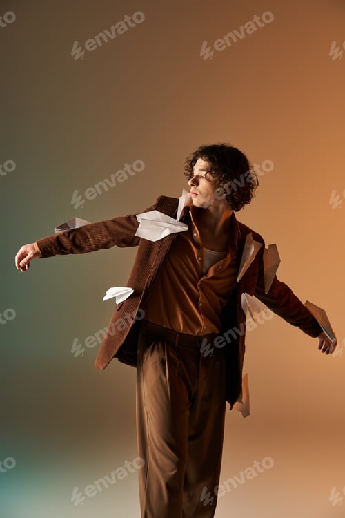 Preview: Curly young man in stylish corduroy blazer adorned with paper planes in studio setting