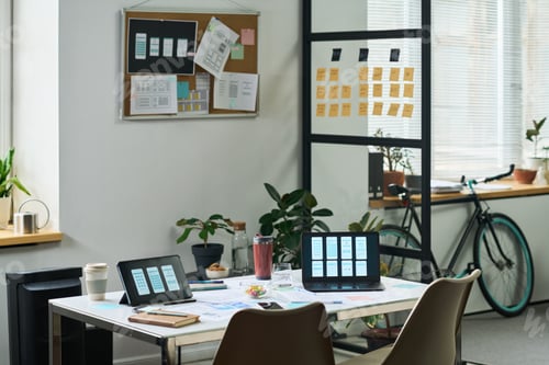 Preview: Modern Office Workspace Featuring Laptops Displaying Mobile App Wireframes